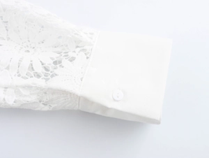 Detailed macro view of white shirt cuff with lace sleeve and classic button closure