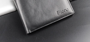 Detailed macro view of high-quality leather texture and fine stitching on a black wallet