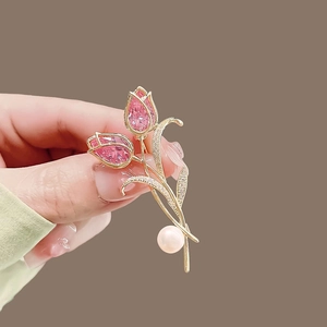 Close-up of golden tulip brooch with pink crystal flowers and pearl inlay detail