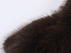 Detailed close-up of dark brown faux fur texture with thick and long synthetic fibers