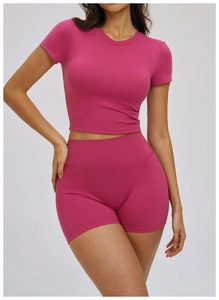 Detailed view of rose red tight yoga set featuring high-waist shorts and short sleeve top