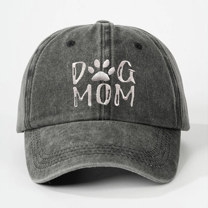 Detailed view of white DOG MOM embroidery and paw print on washed charcoal baseball cap