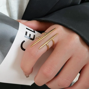 Detailed view of punk style gold ring with triple spike design worn on finger