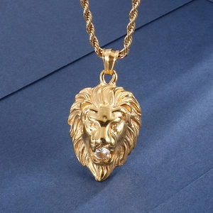 Gros plan du pendentif tête de lion dorée avec cristal et chaîne en maille torsadée