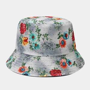 Detailed view of floral bucket hat with red roses and vintage script pattern texture