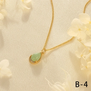 Detailed close-up of 18K gold plated necklace with a green pear-cut gemstone pendant