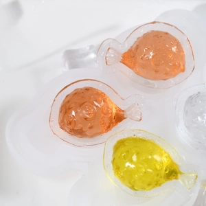 Dettaglio della texture dello stampo in silicone a pesce e cubetti di ghiaccio