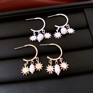 Elegant C-shaped pearl earrings with sun pendants in gold and silver finishes