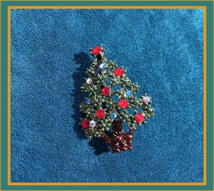 Detailed view of Christmas tree brooch with green metal and colorful rhinestones