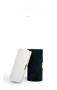 Close-up of portable jewelry storage roll with gold buckle in velvet and leather