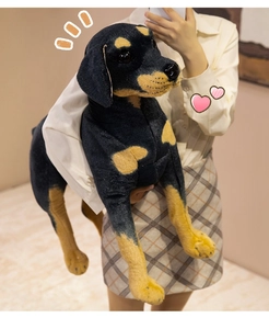 Detailed view of a large black Rottweiler plush toy held to show its realistic size