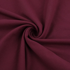 Vista macro detallada de la tela de punto rojo vino profundo con textura suave y pliegues