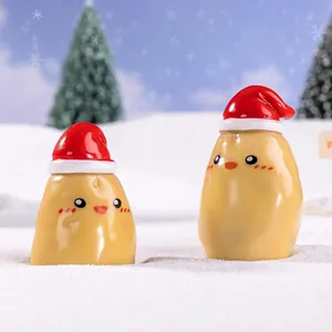 Miniature Christmas potato figurines with Santa hats in a snowy winter landscape
