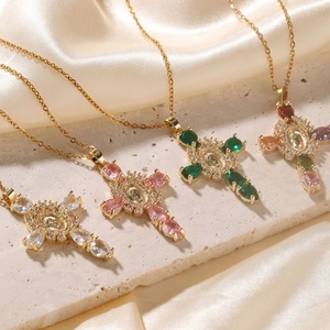 Vintage gold cross pendant necklaces with colorful stones and relief on silk background