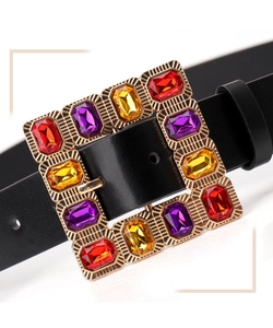 Close-up of golden square buckle with colorful red purple and yellow crystals on black belt