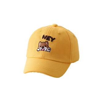 Dettaglio del ricamo a cucciolo e scritta HEY su cappello di cotone giallo per bambini