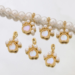 Detail of gold cat paw pendant with white pearls and iridescent heart stone on necklace
