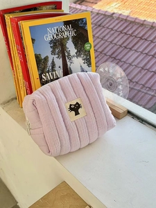 Detailed view of lavender quilted cotton makeup bag with a minimalist black cat patch