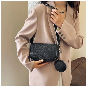 Detail of black woven shoulder bag with removable small round pouch and wide strap