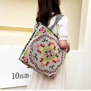 Detail of bohemian canvas tote with floral embroidery and striped strap