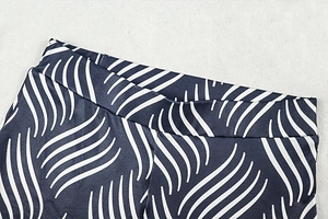 Detail of wide high-waisted band on blue and white wave print leggings for women