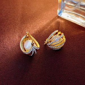 Détail de boucles d'oreilles de luxe françaises avec perles et strass scintillants