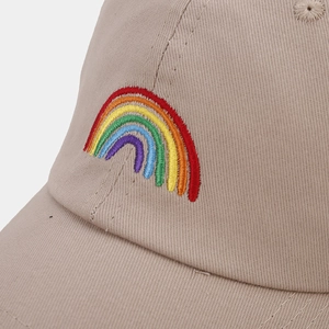 Close-up of vibrant rainbow embroidery on a beige cotton baseball cap with fine stitching
