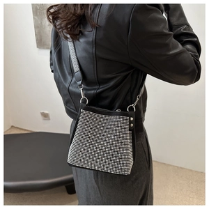 Sac seau noir tendance avec strass argentés et une bandoulière large à chevrons chic