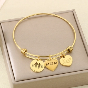 Detail of adjustable gold bangle with Mom, Love, and family silhouette charms