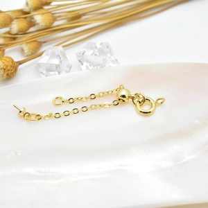 Gold plated DIY jewelry extender chain with adjustable bead on shell background