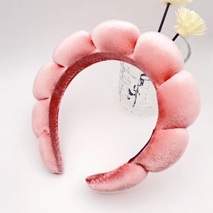 Macro view of a thick pink sponge headband with plush velvet texture and cloud wave design