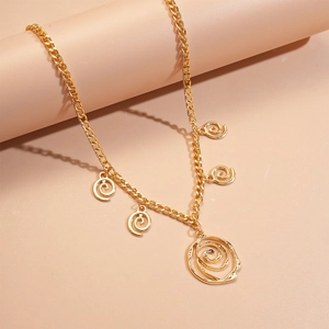 Detailed macro view of golden metal necklace with spiral rose pendants and chunky curb chain
