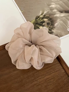 Macro detail of nude organza scrunchie on wooden tray with tulip art background