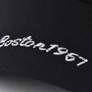 Detail of white Boston 1967 3D embroidery on a black cotton baseball cap surface