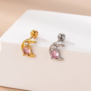 Detailed macro view of gold and silver moon-shaped studs with pink cubic zirconia