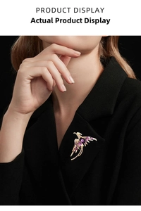 Detail of phoenix brooch with purple enamel and crystals pinned on a black suit jacket