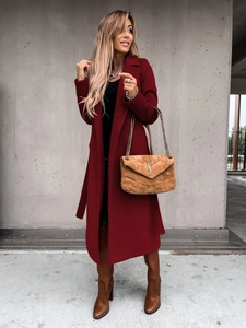 Detail of burgundy wool trench coat featuring a classic lapel and matching waist belt