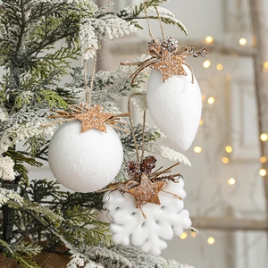White snowy Christmas ornaments set with snowflake and bell shapes on tree