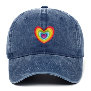 Detail of rainbow heart embroidery on vintage washed cotton baseball cap texture