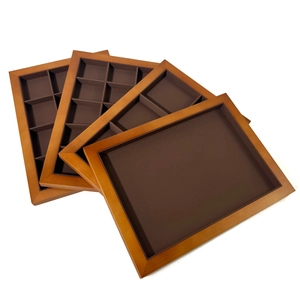 Macro view of four walnut wood jewelry display trays with coffee brown velvet lining
