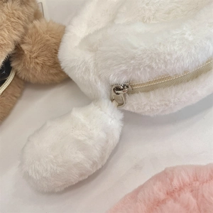Close-up of white plush pencil case with soft faux fur texture and metal zipper detail