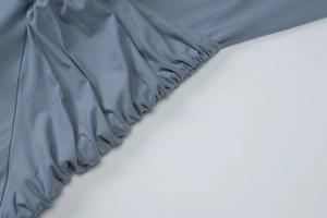 Detailed view of blue-grey ruched fabric texture on this long sleeve summer dress