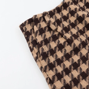 Macro detail of brown and beige houndstooth wool fabric texture with belt loop