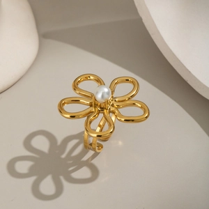 Gros plan détaillé d'une bague fleur en or 18 carats avec une perle blanche centrale sertie