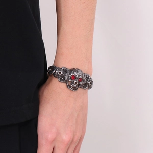 Bracelet punk rétro en acier inoxydable avec breloques crânes aux yeux rouges au poignet