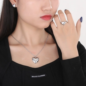 Silver heart necklace and earrings jewelry set worn by model for elegant style
