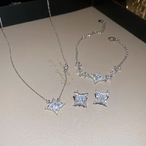 Close-up of sparkling silver star necklace, bracelet and earrings jewelry set on a gift box