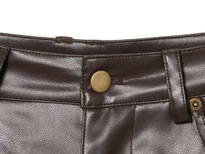Dettaglio dei pantaloni in ecopelle marrone scuro con bottone metallico e chiusura lampo