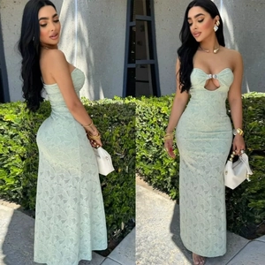 Detail of mint green lace maxi dress showing cut-out floral texture and metal hardware
