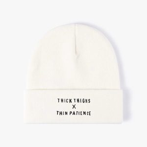 Off-white knit beanie with Thick Thighs x Thin Patience embroidery on the folded cuff